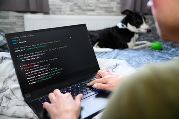 Coding in the house, a woman writing code on a laptop for an app or website while working from home