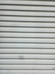 A metal shutter door in broken white color