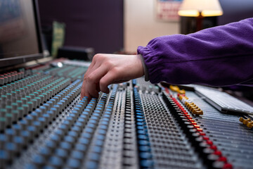 Wall Mural - Sound control panel professional. Sound designer working on the sound control. Man working on professional digital audio channel mixer in studio