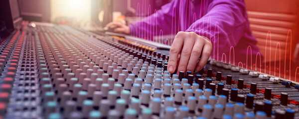 Wall Mural - Sound control panel professional. Sound designer working on the sound control. Man working on professional digital audio channel mixer in studio