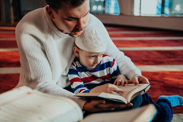 Wall Mural - Muslim prayer father and son in mosque praying and reading holly book Quran together islamic education concept