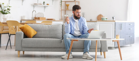 Male psychologist with laptop video chatting with patient at home