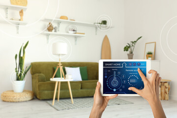 Canvas Print - Woman's hands holding tablet computer with smart home security system on screen in living room