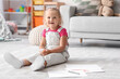 © Pixel-Shot - Cute little girl with felt-tip pens sitting on floor at home