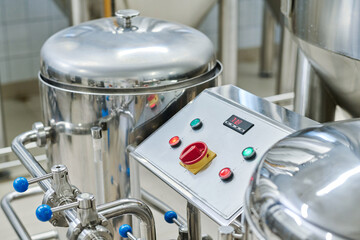 Close-up of modern equipment with big metal barrels and control panel for brewing beer