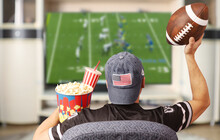 Fan Of American Football. Man With A Ball Watching TV.