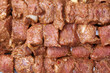 Raw beef with onions marinated with spices in a frying pan on a light texture background. Meat recipe. Juicy grilled steak, close-up. Place for text, space for copy.