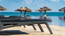 Sun Beds In A Tropical Setting Overlooking Parasols And The Sea