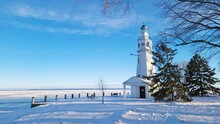 Lighthouse In Winter With Frozen Lake Background 