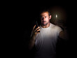© javidestock - Man looking at his cell phone with a match in the dark. Blackout concept. Selective focus.