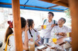 © Odua Images - Four asian students in uniforms joking while drinking ice at the stall