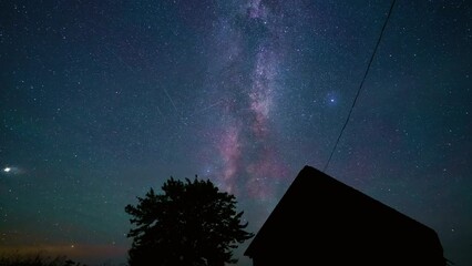 Wall Mural - starry sky turning space with milky way above countryside house, astrophotography time lapse