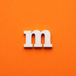 m white lowercase letter - Background in orange foamy