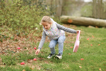 Wall Mural - Girl looking for eggs in a bag for Easter