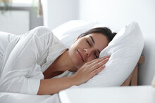 Beautiful young woman sleeping on soft pillow in bed at home