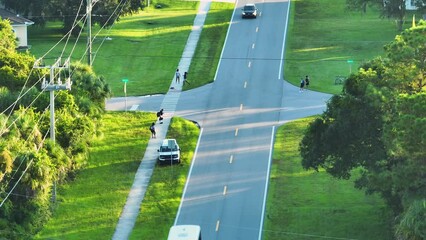 Sticker - Top view of schoolkids waiting for school bus to arrive in time. Kids standing on suburban street sidewalk ready to be picked up in early morning. Public transportation in the USA