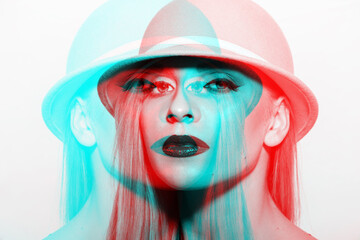 Wall Mural - Studio portrait of beautiful woman with fancy make-up in red and blue color split effect. Model wearing retro hat and looking at camera with serious and seductive look. Futuristic looking style