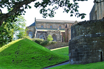 Wall Mural - Ancient Stone Church with Trees and Green Grassy Lawns on Sunny Day