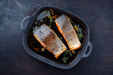 Wall Mural - Traditional Japanese salmon fish teriyaki filet with soy souce and spinach as top view in a Nordic design pan