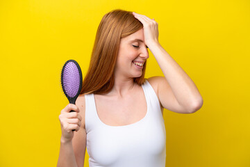 Wall Mural - Young redhead woman holding a hairbrush isolated on white background has realized something and intending the solution