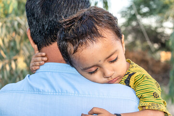 Asian refugee with his sick child at a border