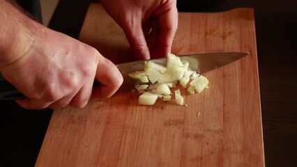 Canvas Print - man hands cutting white onion close up in wooden board