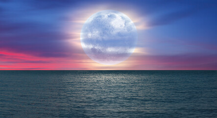 Wall Mural - night sky with moon in the dark clouds and darkblue sea in the foreground 