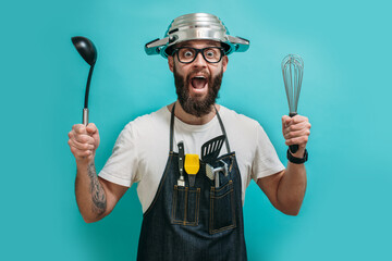 Wall Mural - Funny bearded crazy chef with a pan on his head. Cooking. Crazy emotions