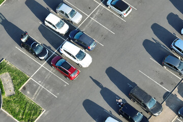 Canvas Print - Aerial view of many colorful cars parked on parking lot with lines and markings for parking places and directions