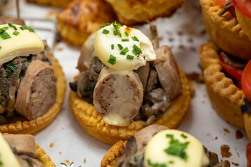 Wall Mural - French mini quiche pie with goat cheese and traditional French sausage Andouillette from Troyes in bakery