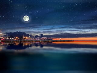 Wall Mural - night sea water blurred city light,blue water wave reflection starry sky and moon in italy port harb