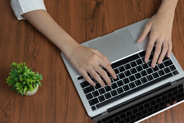 Wall Mural - woman working and typing on the keyboard on table at home.Top view