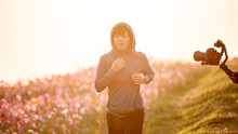 Woman Jogging In The Flower Garden In The Morning