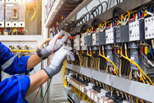 Electricity Or Electrical Maintenance Service, Engineer Hand Checking Electric Current Voltage At Circuit Breaker Terminal And Cable Wiring Check In Main Power Load Center Distribution Board.