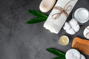 Natural body care cosmetics on concrete background. Spa accessories, towel, hairbrush, essential oil.