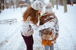 © Alliance - stylish mother and daughter shaking snow off clothes