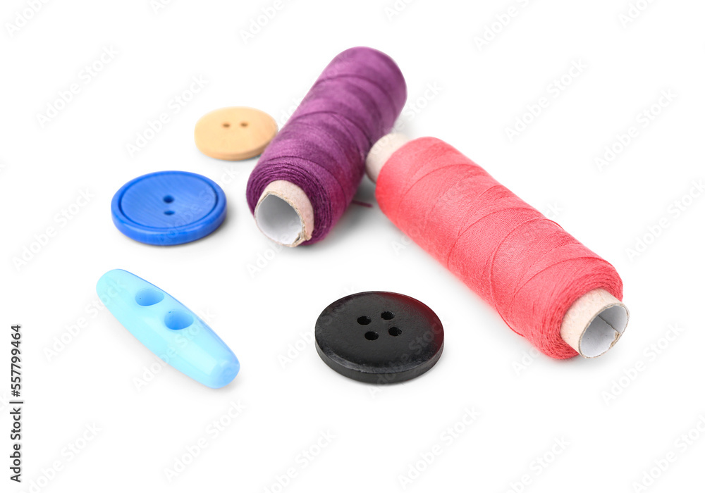 Colorful thread spools and buttons on white background