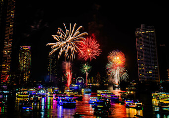 BANGKOK, THAILAND - JANUARY 1,2023 : The countdown firework show at Asiatique Riverfront in Bangkok. Colourful of fireworks on the river on Chao Praya River.