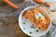 Carrot salad with yogurt dressing on wooden table with space for text