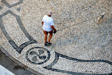 Man And Dog On A Traditional Portuguese Style Pavement For Pedestrian Area In Olhao, Algarve, Portugal