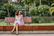 © ADDICTIVE STOCK - Smiling woman resting on bench in park