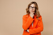 © ViDi Studio - Young successful employee business woman corporate lawyer 30s wears classic formal orange suit glasses work in office prop up chin look aside on area isolated on plain beige color background studio.