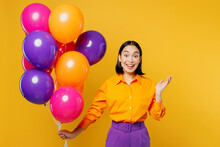 Happy Fun Surprised Shocked Young Woman Wearing Casual Clothes Celebrating Holding Bunch Of Colorful Air Balloons Spread Hands Isolated On Plain Yellow Background. Birthday 8 14 Holiday Party Concept.