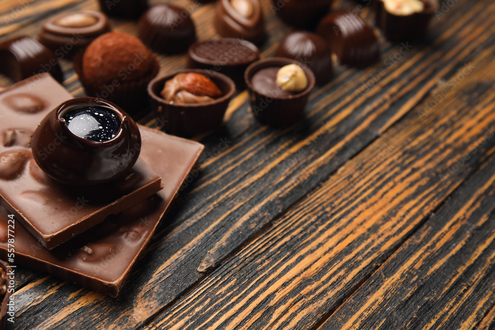 Chocolate bars and candies on wooden background, closeup