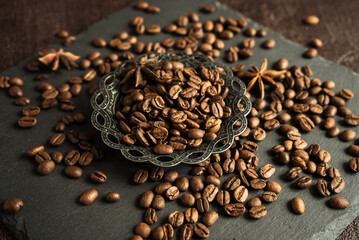 Wall Mural - aromatic roasted coffee beans with spices, anise and metal turkish bowl on black background 2