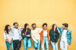 Leinwandbild Motiv Happy multiracial friends standing over isolated background - Cheerful young people socializing outdoors - University students laughing together on yellow wall - Youth culture and friendship concept