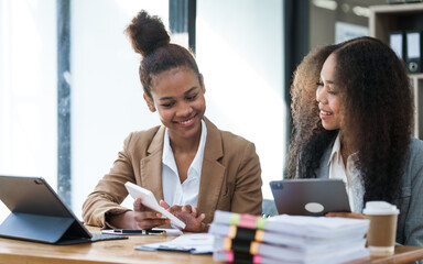 Wall Mural - An African American businesswoman participates in a staff meeting and working together at workplace.