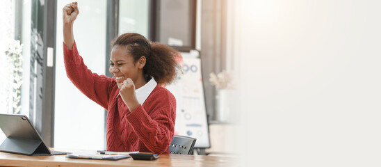 Wall Mural - Smiling African American Hispanic student looking up from laptop at campus library, using tablet and mobile