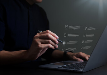 Businessman evaluating with checkboxes on online laptop computer. assessment survey online, choose correct answer in test, questions test, online exam, quiz knowledge, filling out an survey form.