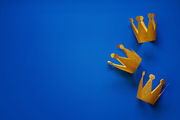 Happy Epiphany Day, Three Kings Day greeting card with three gold crowns on blue background. Concept for Dia de Reyes Magos day, three Wise Men, Epiphany Christian feast day